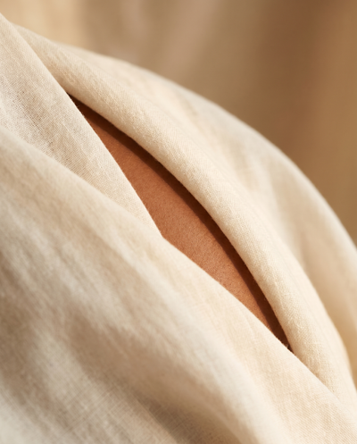 Layla · Tone V · Bikini line · Week 8 — abstract macro: smooth skin peeking under draped beige linen
